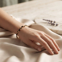 Gold plated tulip bracelet featuring jet black oval gemstones and black leaf accents by Trivo Essentials