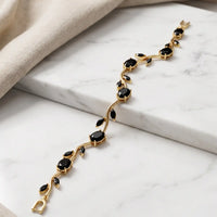 Gold plated tulip bracelet featuring jet black oval gemstones and black leaf accents by Trivo Essentials