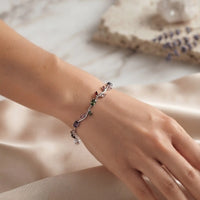 Rhodium silver plated tulip bracelet featuring multi-color oval gemstones and champagne leaf accents by Trivo Essentials