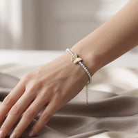 Two-tone silver and gold tennis bracelet with brilliant CZ crystals and a central butterfly charm by Trivo Essentials